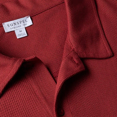 Close-up fabric texture of the Sunspel Riviera Polo Shirt Garnet Red showing the airy mesh cotton weave.
