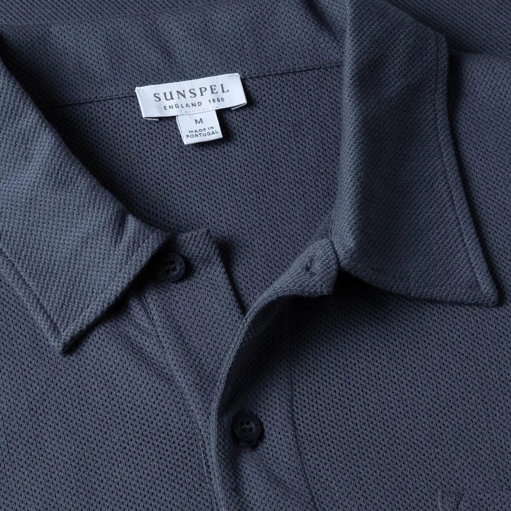 Close-up of the collar of the Sunspel Riviera Polo Shirt Slate Blue showing the breathable mesh cotton and refined neckline.
