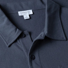 Close-up of the collar of the Sunspel Riviera Polo Shirt Slate Blue showing the breathable mesh cotton and refined neckline.
