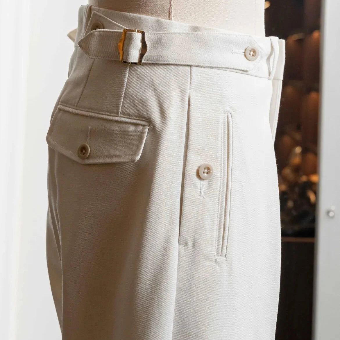 Side profile of the Tangent Tan 04° Charles Hard Twist Twill Off White trousers highlighting the structured twill fabric and side adjusters