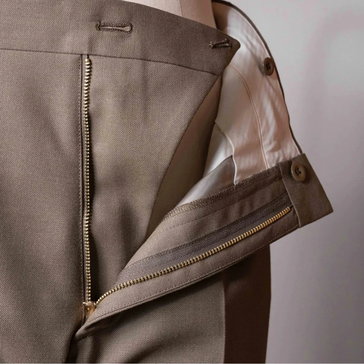 Close-up of the zipper area of the Tangent TAN24 Pepe Khaki trousers, showing the fly construction, stitching, and hardware details.