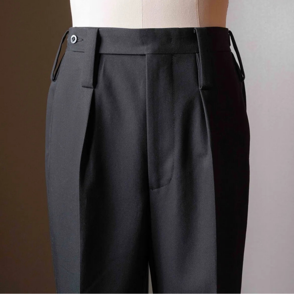 Side profile of the Tangent TAN25 Pat Black trousers highlighting the smooth fabric and sharp drape.