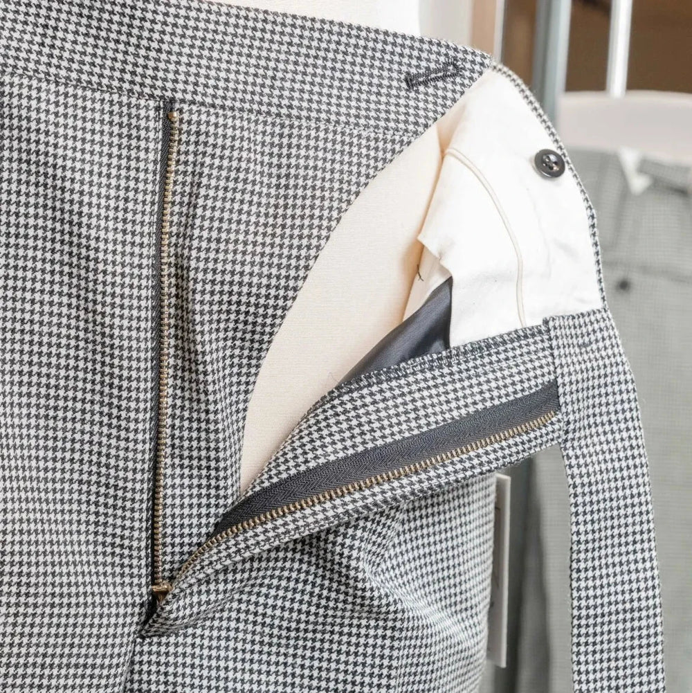 Close-up of the waistband of the Tangent Tan 25° Wool Check Hound Tooth trousers showing adjusters and button details.