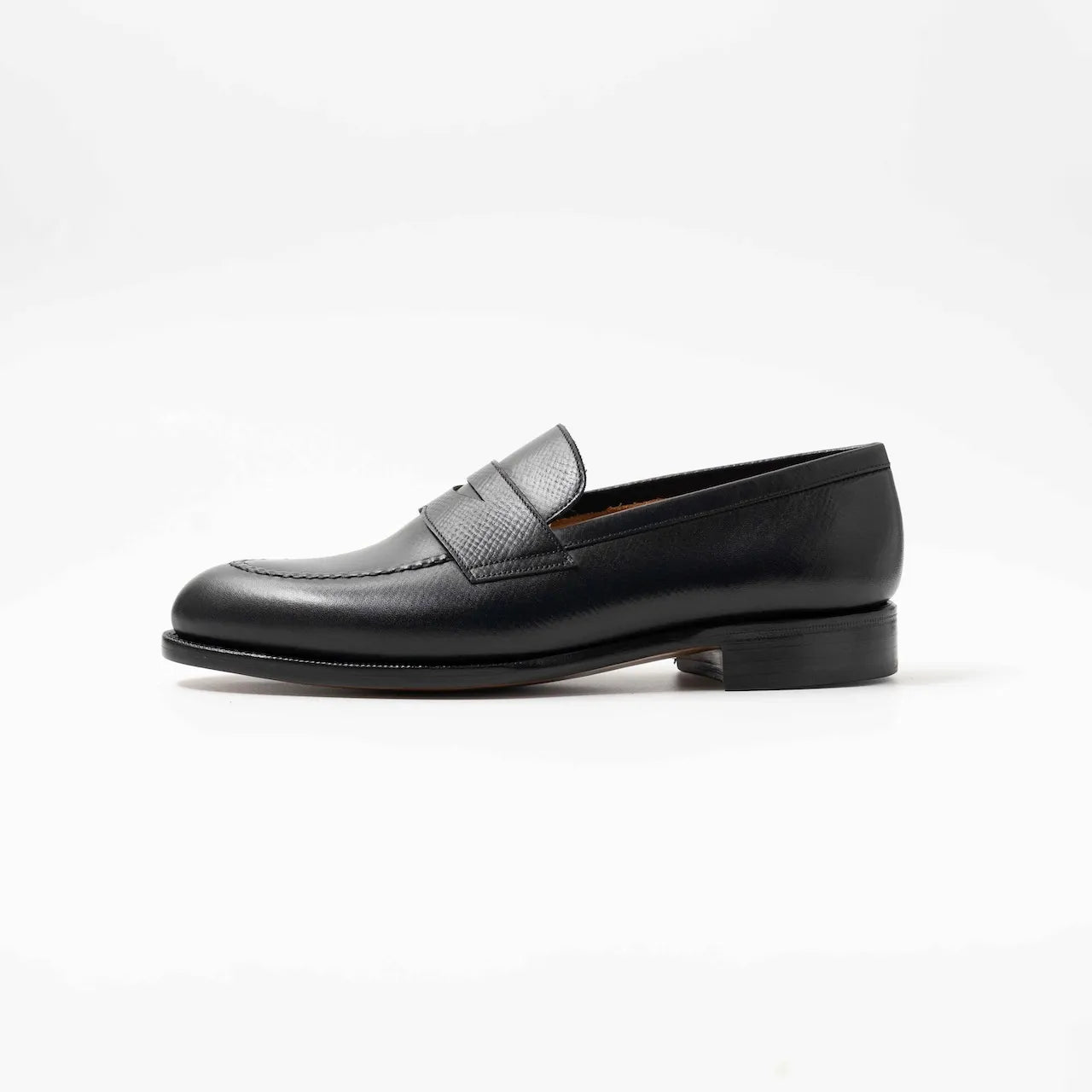 Side profile of the TLB Mallorca Jones Penny Loafer in black hatch grain leather with a sleek design and single leather sole.