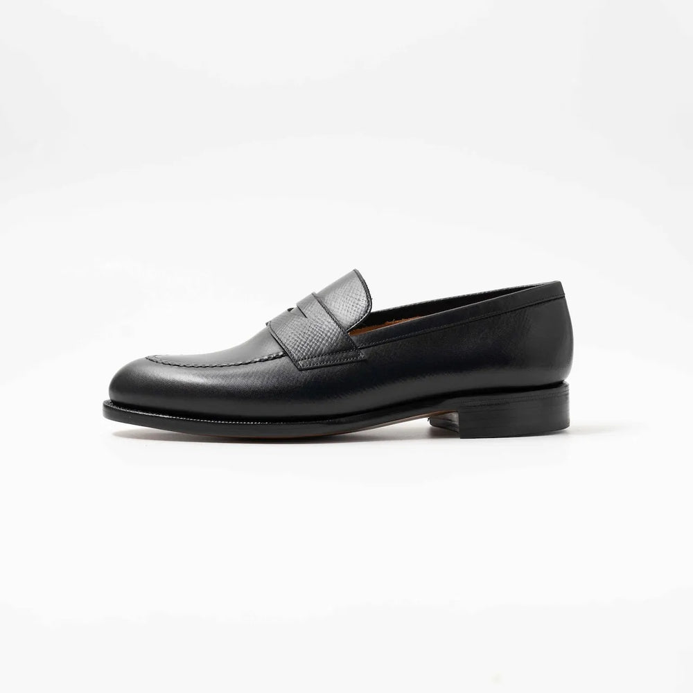 Side profile of the TLB Mallorca Jones Penny Loafer in black hatch grain leather with a sleek design and single leather sole.