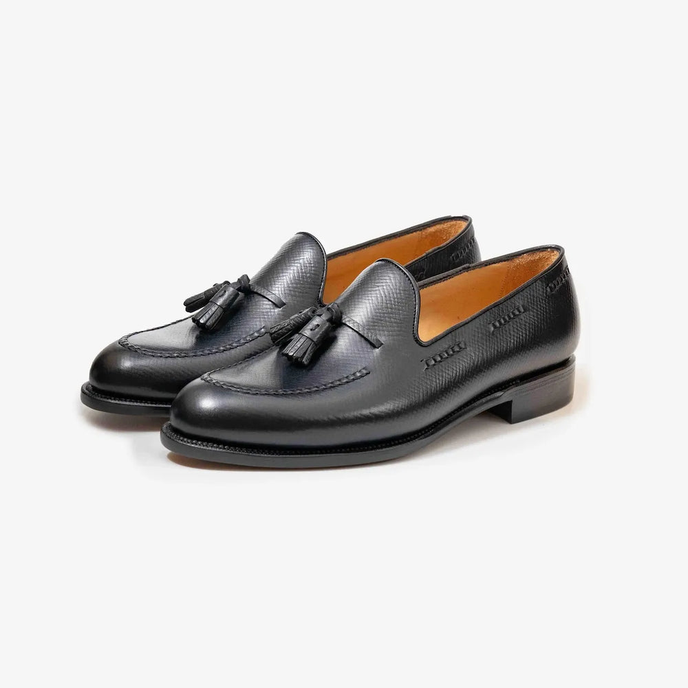 Rear view of the black hatch grain tassel loafers highlighting the heel shape and back seam craftsmanship.