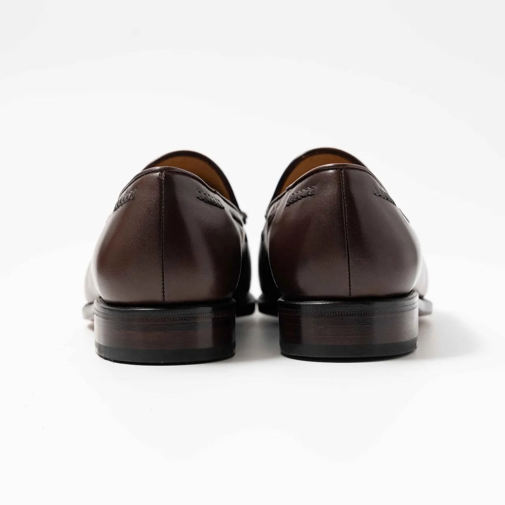 Rear view highlighting the heel shape and craftsmanship of the dark brown vegano tassel loafers.