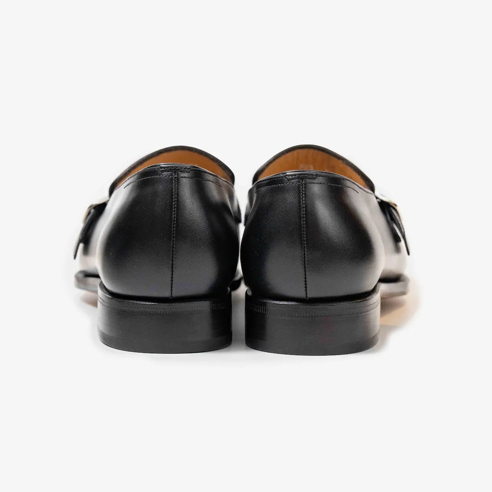 Rear view highlighting the heel construction and smooth finish of the black box calf leather loafers.