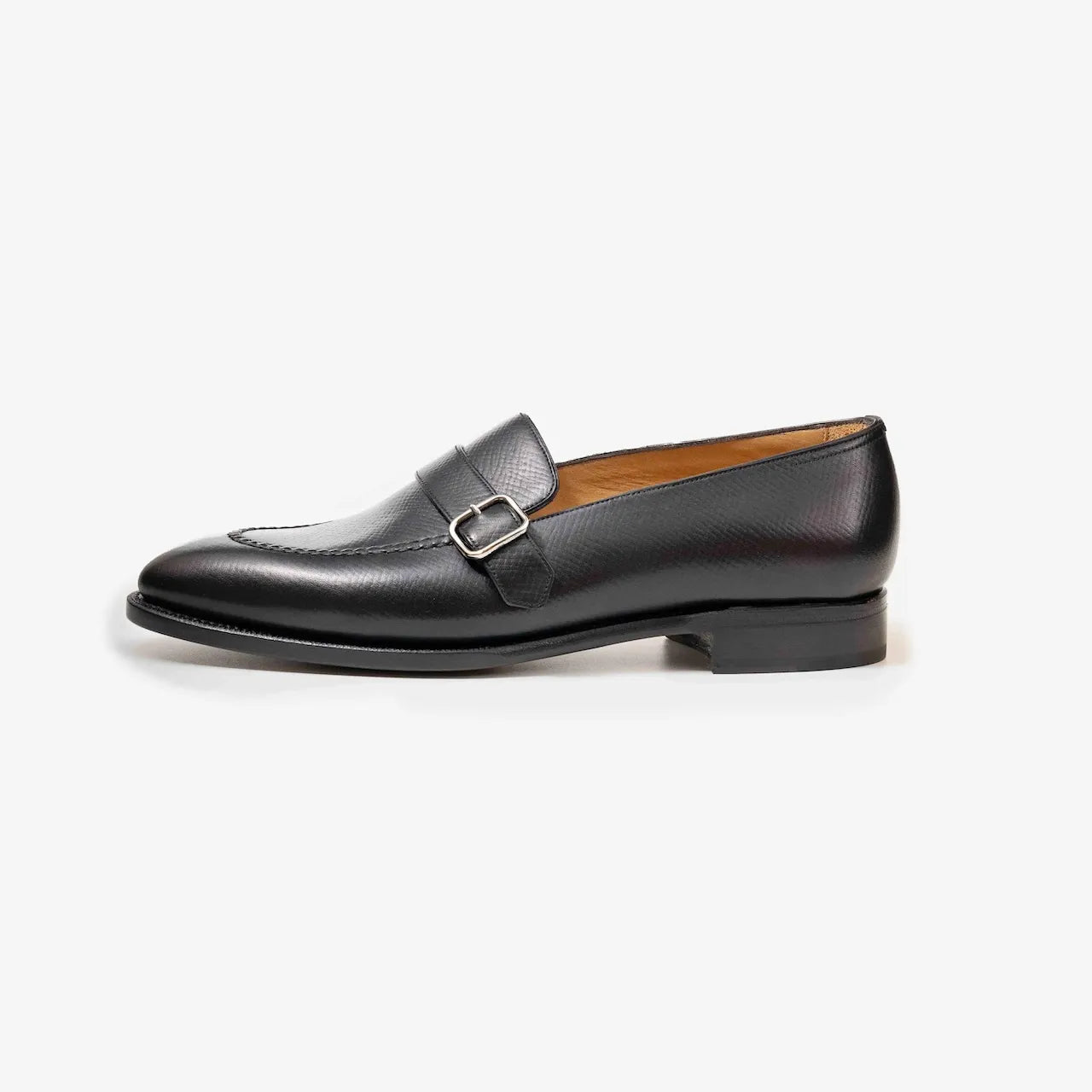 Side profile of the TLB Mallorca Goya Buckled Loafer in black hatch grain leather with a sleek silhouette and single leather sole.