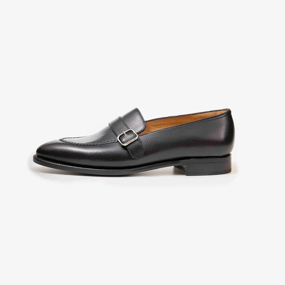 Side profile of the TLB Mallorca Goya Buckled Loafer in black hatch grain leather with a sleek silhouette and single leather sole.