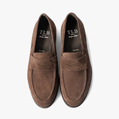Close-up of the dark brown suede leather showing soft nap and refined texture.