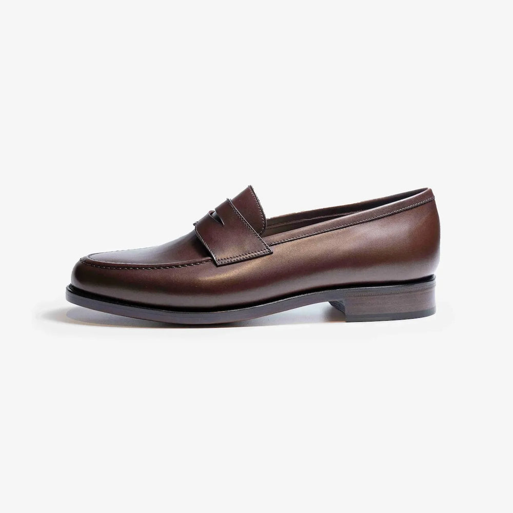Side profile of the TLB Mallorca Queens Penny Loafer in dark brown vegano leather with a sleek shape and single leather sole.