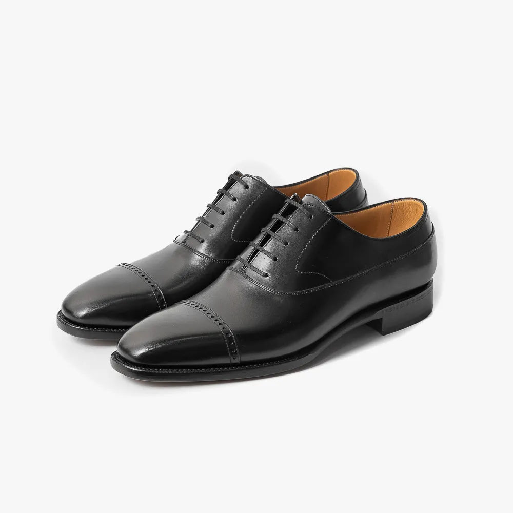 Close-up of the black box calf leather showing smooth grain and polished finish.