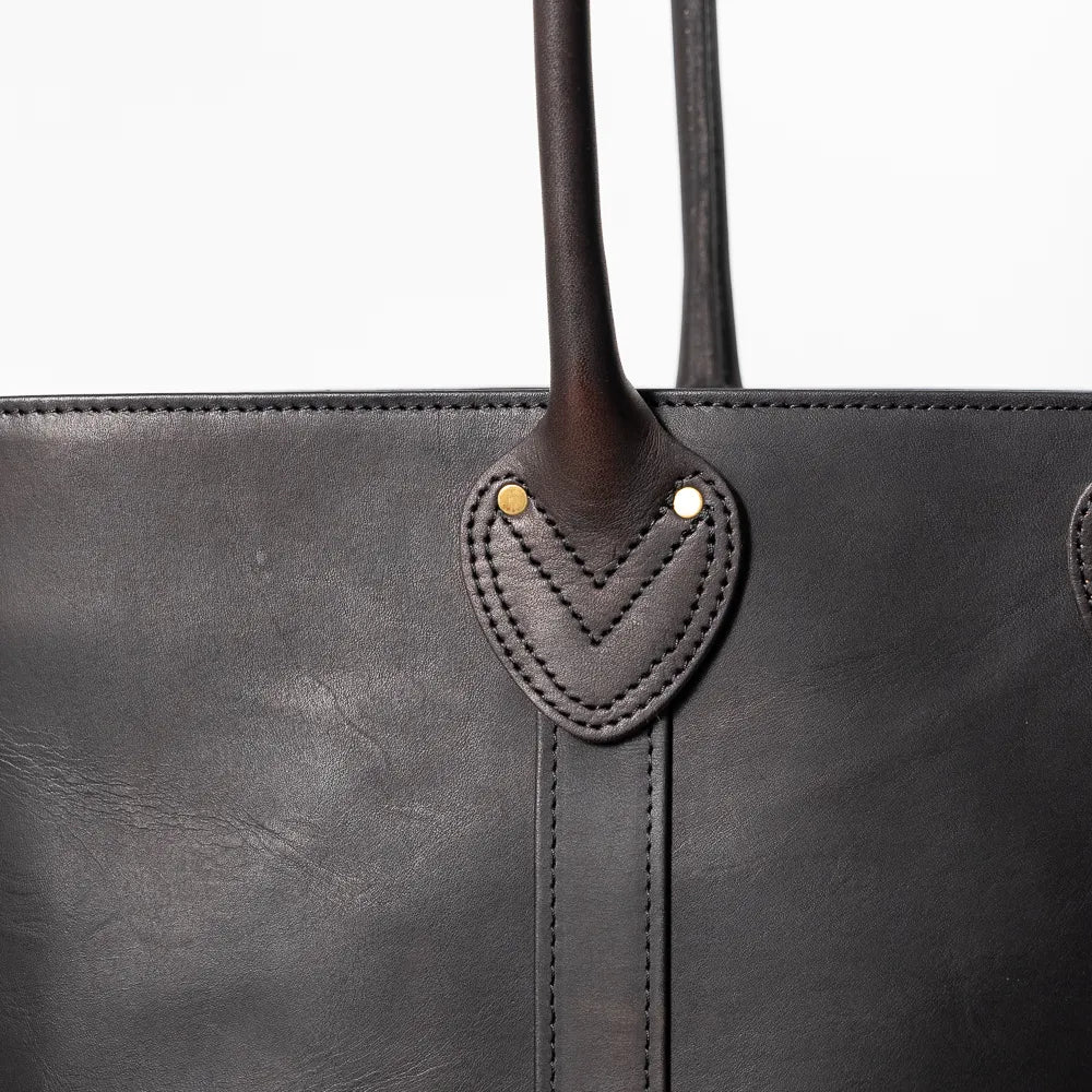 Close-up of the handle and hardware detailing showing solid construction, stitching precision, and durable metal fittings.