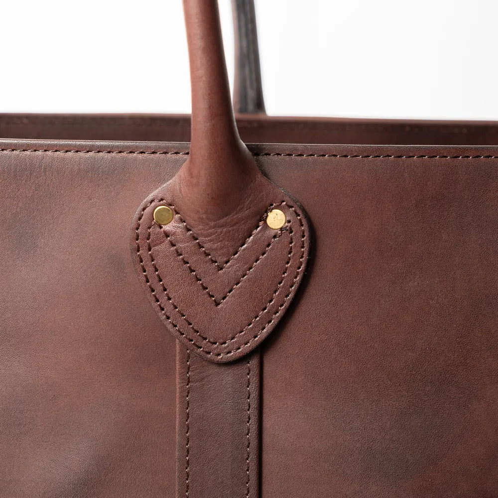 Close-up of the handle and hardware showing sturdy stitching and durable metal fittings.