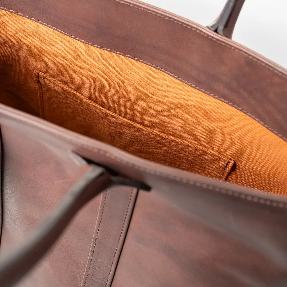 Close-up of the interior slip pocket inside the Vasco x Refinement Leather Tote Brown showing practical storage and leather finish.
